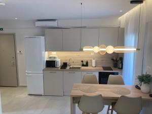 a kitchen with white cabinets and a table with chairs at La casa di Zoe in Flogita