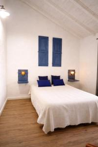 a white bedroom with blue windows and a bed at Monte da Rocha 3 Marias in São Bartolomeu da Serra +32 photos
