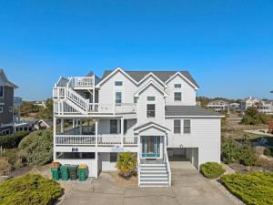 a large white house with a balcony at Sandcastle in Corolla