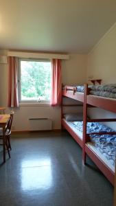 a room with three bunk beds and a window at HI Borlaug Vandrerhjem in Borgund