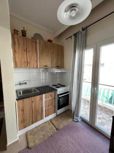 a kitchen with a stove and a sink and a window at petite apartment in Asprovalta