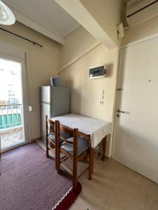 a small kitchen with a table and a refrigerator at petite apartment in Asprovalta