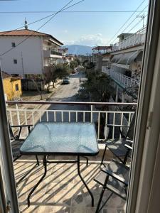 a balcony with a table and a view of a street at petite apartment in Asprovalta