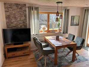 a living room with a wooden table and a television at Grünes Stüble - Haustiere auf Anfrage in Altusried