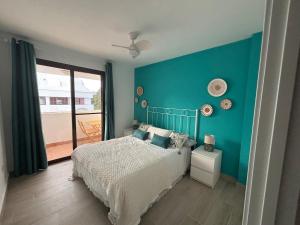 a bedroom with a bed and a blue wall at Beautiful house with ocean views in La Cala de Mijas