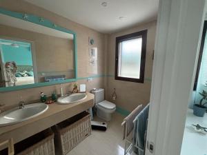 a bathroom with two sinks and a toilet and a mirror at Beautiful house with ocean views in La Cala de Mijas +20 photos
