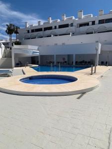 a large building with a swimming pool in front of a building at Beautiful house with ocean views in La Cala de Mijas
