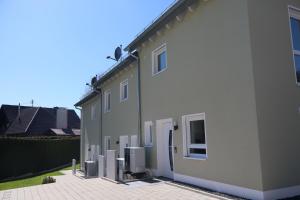 a white house with refrigerators on the side of it at Ferienhaus Ferati - Modernes Neubau-Haus & nahe Legoland in Günzburg