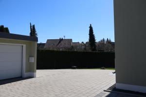 a parking lot with a garage and a fence at Ferienhaus Ferati - Modernes Neubau-Haus & nahe Legoland in Günzburg