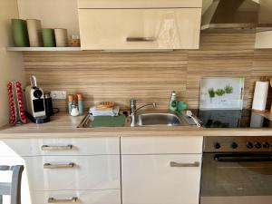 a kitchen with white cabinets and a sink at Grünes Stüble - Haustiere auf Anfrage in Altusried +7 photos