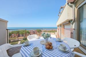 a table on a balcony with a view of the ocean at Residenze Etruria in San Vincenzo