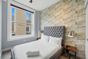 a bedroom with a bed and a brick wall at The Plymouth Chicago in Chicago
