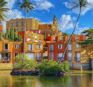 a group of buildings with palm trees and water at Port Chambly Waterside Villa in Terre Rouge
