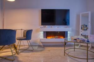 a living room with a fireplace with a tv above it at Elegant apartment with pool and parking in Losone
