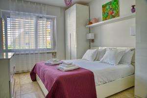 a bedroom with a bed with towels on a table at Elegant apartment with pool and parking in Losone +40 photos
