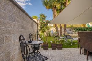 a patio with a table and chairs and an umbrella at Elegant apartment with pool and parking in Losone