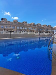a large blue swimming pool with buildings in the background at PepeHills in Gran Alacant