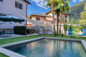 a swimming pool in the yard of a house at Elegant apartment with pool and parking in Losone