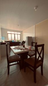 a kitchen with a table and chairs in a room at Suíte Luxo Casal Duplo in Areia