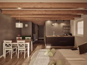 a kitchen and living room with a table and chairs at Guesthouse Odle in Funes