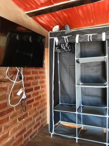 a room with a bed and a tv and a brick wall at Buena Vista in Taganga