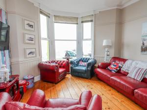 a living room with red leather couches and chairs at The View in Criccieth