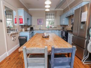 a kitchen with a wooden table and blue cabinets at The View in Criccieth