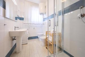 a white bathroom with a sink and a toilet at Residenze Etruria in San Vincenzo +58 photos