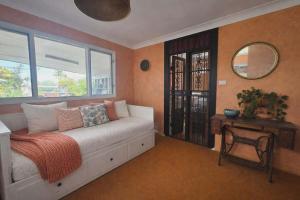 a bedroom with a bed with a mirror and a table at Hidden Gem in the CBD in Coffs Harbour