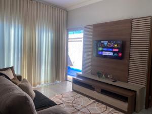 a living room with a couch and a flat screen tv at Casa Betel in Anápolis