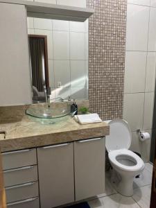 a bathroom with a sink and a toilet and a mirror at Casa Betel in Anápolis +7 photos