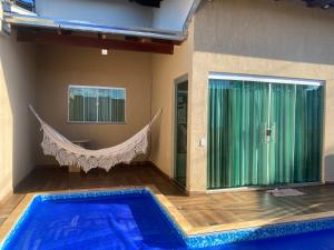 a swimming pool with a hammock in a room at Casa Betel in Anápolis