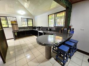 a large kitchen with a table and stools at La Martha in Sarapiquí
