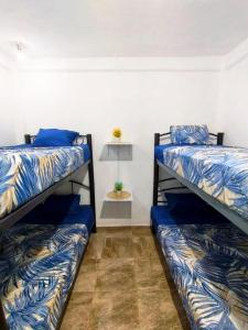 a room with three bunk beds and a table at Casa Los Reyes in La Magdalena Atlipac