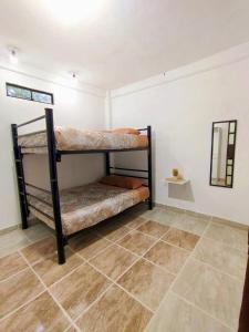 a room with two bunk beds and a tile floor at Casa Los Reyes in La Magdalena Atlipac +11 photos