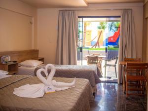 a hotel room with two beds with swans on them at Hotel Privê do Atalaia in Salinópolis +52 photos