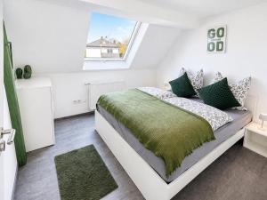 a white bedroom with a bed and a window at Family & Work Apartment in Schopfloch