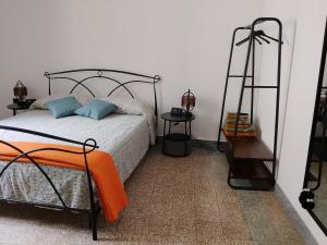 a bedroom with a bed with an orange blanket on it at CASTEDDU rooms in Cagliari
