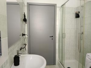 a bathroom with a sink and a glass shower at CASTEDDU rooms in Cagliari