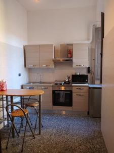 a kitchen with a wooden table and a table and chairs at CASTEDDU rooms in Cagliari