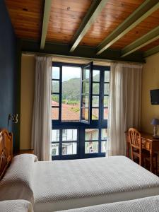 a bedroom with a bed and a large window at Hotel Cuevas Del Mar in Nueva de Llanes