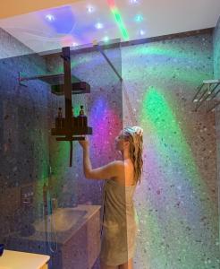 a woman is painting a wall with a rainbow at Gravina Boutique Apartment in Gravina in Puglia +21 photos