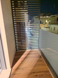 a room with a window with blinds and a wooden floor at Gravina Boutique Apartment in Gravina in Puglia