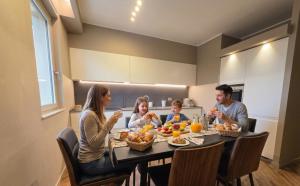 a family sitting around a table eating food at Gravina Boutique Apartment in Gravina in Puglia