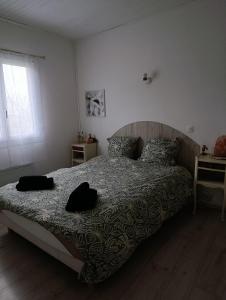 a bedroom with a bed with two pillows on it at Au fil des mains in Le Houga