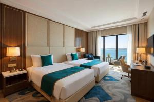 a hotel room with two beds and a television at Hotel Grand Tela Suite Delhi in Gurgaon