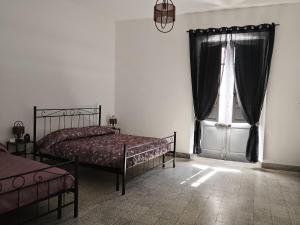 a bedroom with two beds and a window at CASTEDDU rooms in Cagliari +7 photos