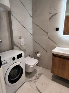 a bathroom with a washing machine and a toilet at Becici residance pool and sauna in Bečići