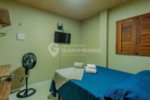 a bedroom with a blue bed and a fan at Flat Guaramiranga - Apto 201 in Guaramiranga