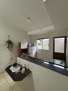 a kitchen with a counter top and a refrigerator at Ap Perfeito! Condomínio fechado e garagem coberta in Tangara da Serra +11 photos